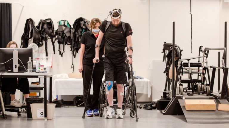 Man with paralysis walks naturally after brain, spine implants