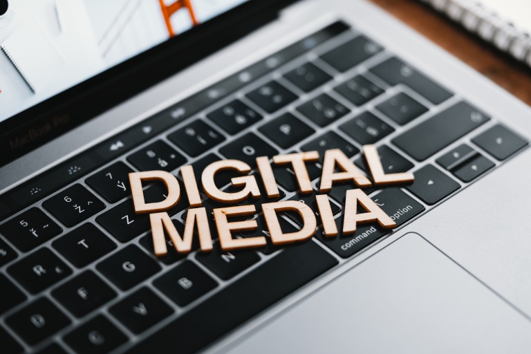 A laptop with the words "Digital Media" superimposed across the keyboard. Photo by Viktor Hanacek from picjumbo.com