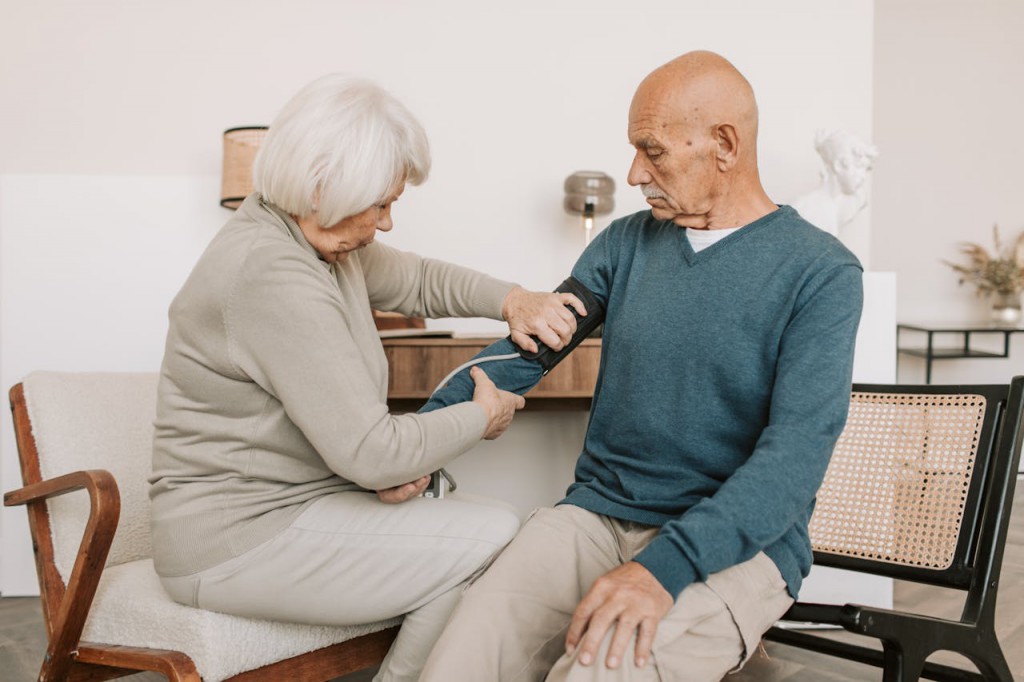Elderly Woman Checking the Blood Pressure of an Elderly Man. Photo by Vlada Karpovich via Pexels.